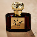 Perfume bottle with gold cap and Arabic text on a beige background